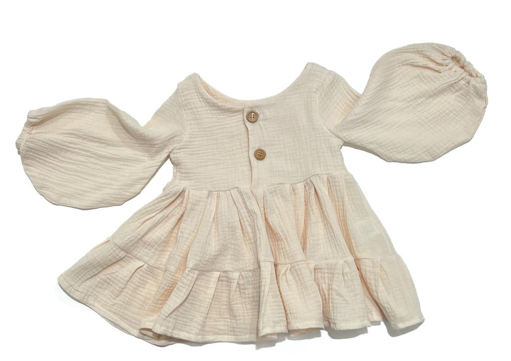 Buttermilk is the perfect neutral tone, long sleeve smock dress. Handmade from muslin with elastic wrist cuffs and a button closure back. This is the perfect dress for little girls who love to twirl.
