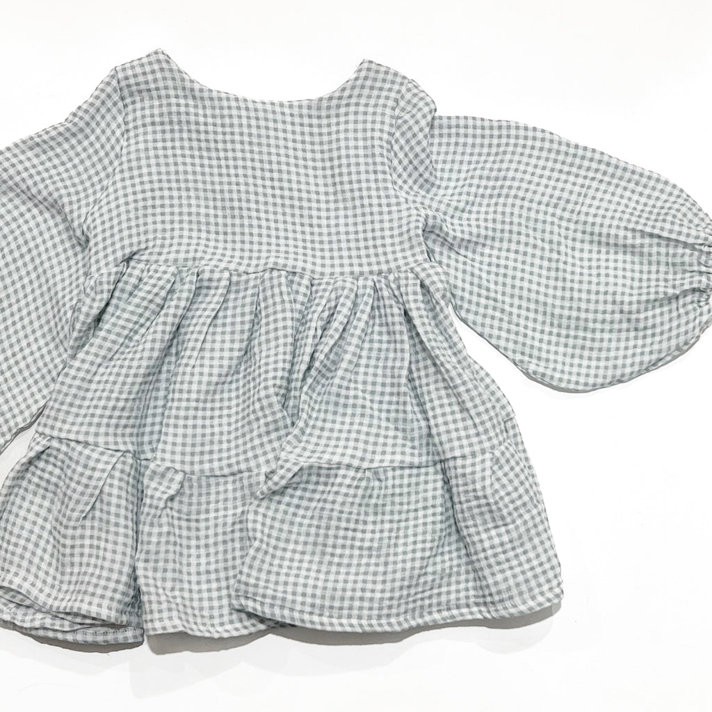 Our smock dress is a stunning piece that is perfect for twirling. Handmade with care in Australia. Made from a soft, lightweight, blue gingham muslin fabric, it feels comfortable against your child's skin.
The smock dress features a simple yet elegant design, with a classic round neckline, bell sleeves, and a flowing tiered skirt. The dress is available in a range of sizes to accommodate children of all ages, and its timeless design means it can be worn again and again for years to come.