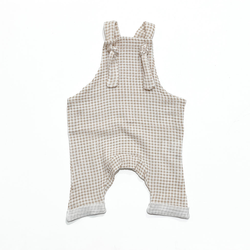 Handmade in Coffs Harbour, NSW, Australia, these beige and white gingham, muslin overalls have been thoughtfully designed for growing children. Made with a gusset crutch, extra length in the legs so they can be rolled for prolonged wear, and adjustable tie shoulder straps. 