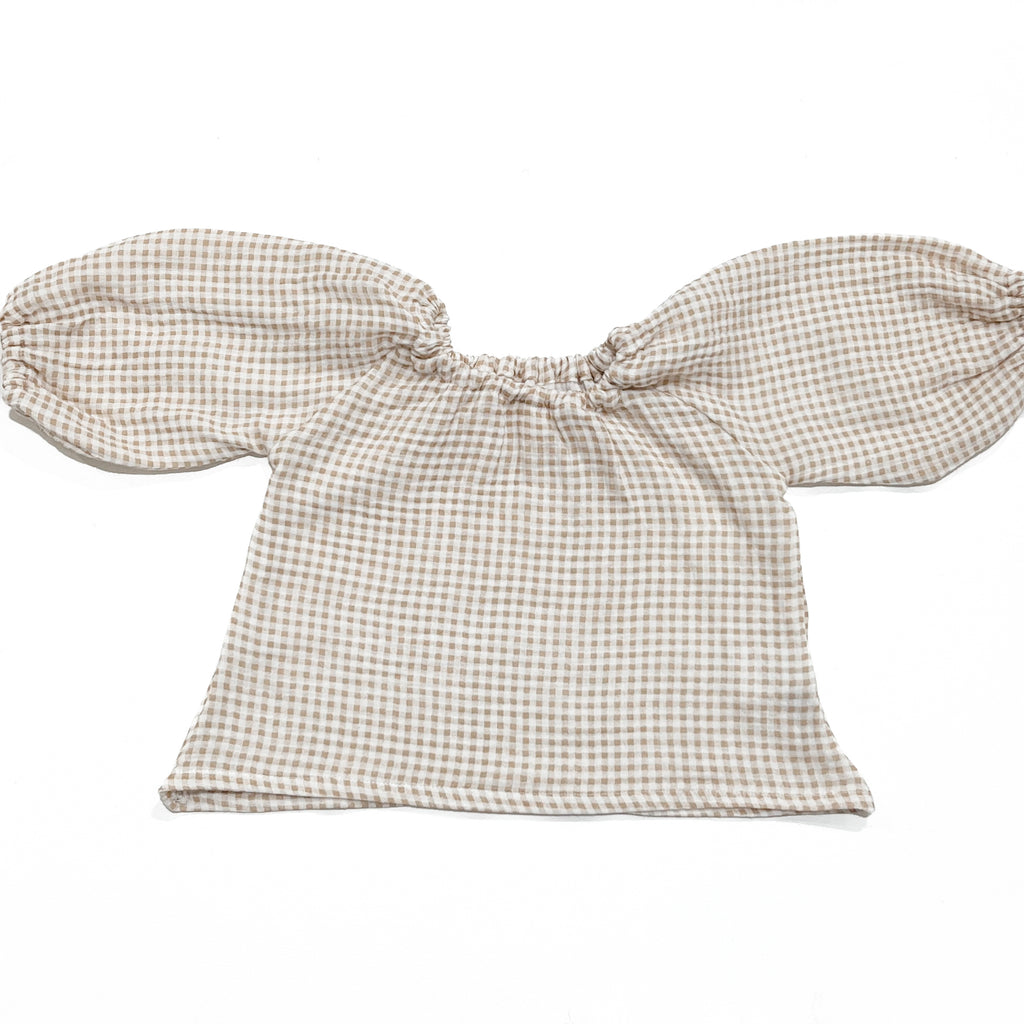 Our handmade smock tops are made with a soft beige oat and white gingham cotton muslin that will just get better with wear age. With a handkerchief hem and elastic cuff bell sleeves, it’s perfect layered under our overalls or paired with our harems, bloomers, frill shorts.