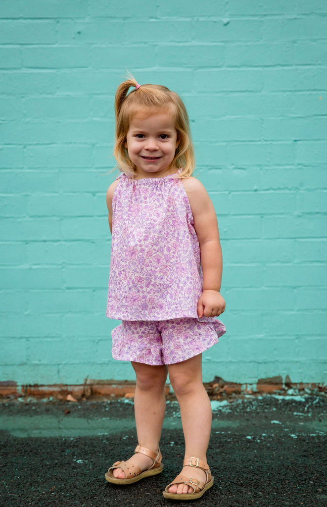 Our handmade in Australia, Frill Shorts are made with a soft natural linen that will just get better with wear and age. They have elastic waists to assist those parents who have to wrangle a wriggle worm just to get them dressed. In our ‘Aglow’ purple, lavender and mauve floral print, these frill hem shorts are the perfect combination of cute and functional.