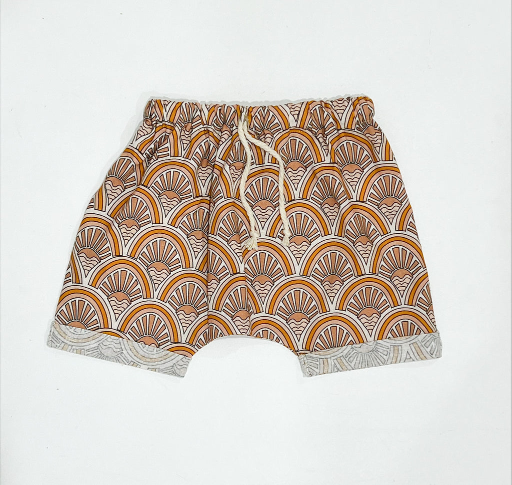 Our handmade Shorts are made with a soft natural linen that will just get better with wear and age. They have functioning draw string waists to assist those little ones who need help to keep their pants up. The perfect fun neutral in our tan, white and muted orange ‘sunrise’ print. 