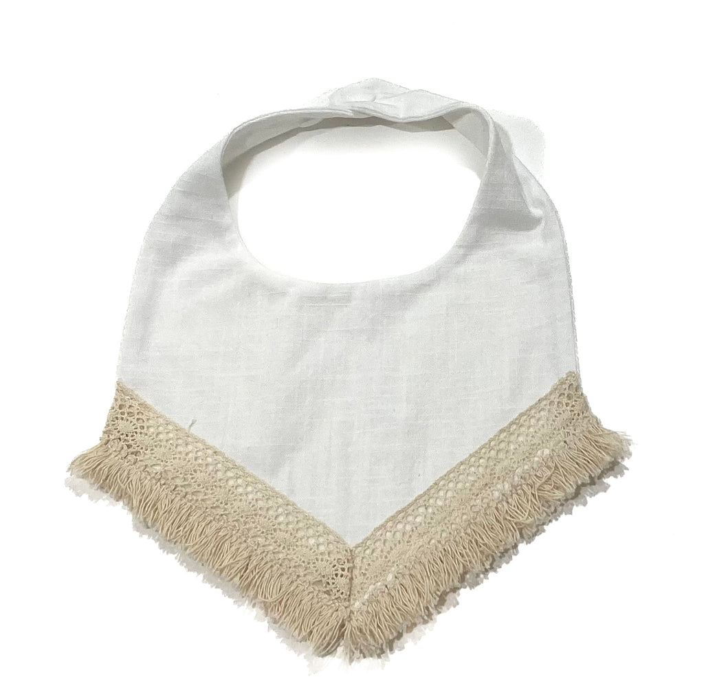 White / milk, textured linen. Handcrafted into a children’s bib with a tassel edge and adjustable clip back.