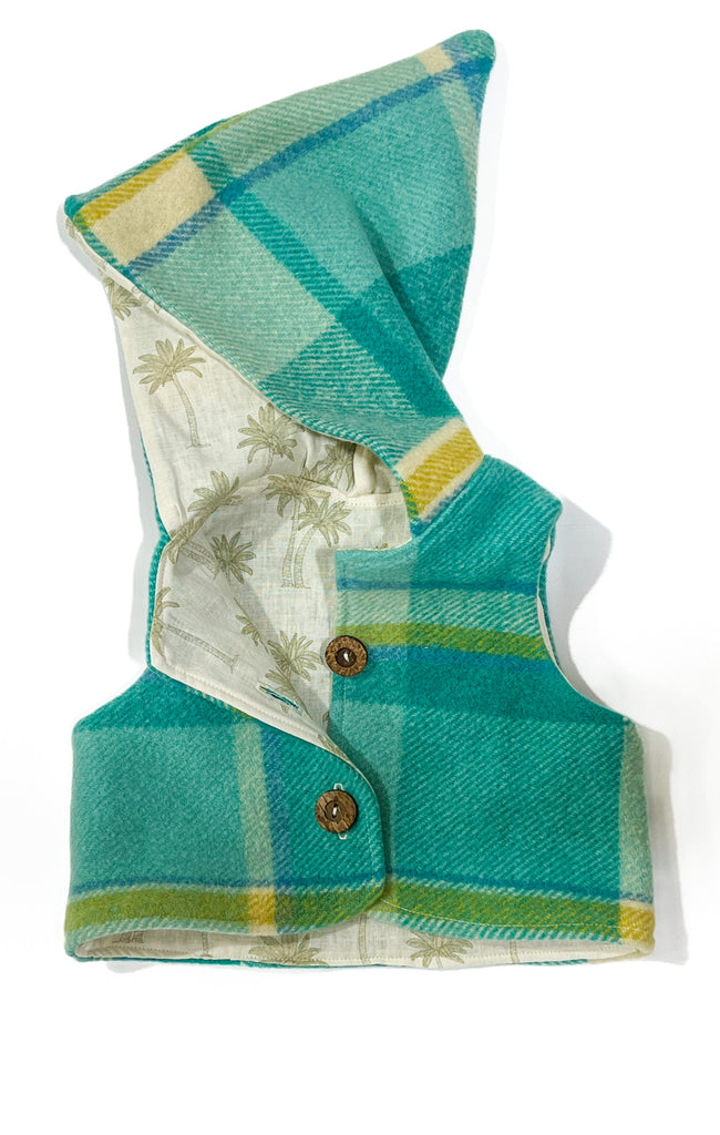 Handmade vests are made from 100% wool ~ upcycled from a blanket in excellent condition. This vest is fully lined with our palms linen / cotton fabric. 

Absolutely gorgeous on and perfect for layering, with a hood to keep their ears warm.

The vests are true to size. You can size up to get 2 winter seasons out of them. 