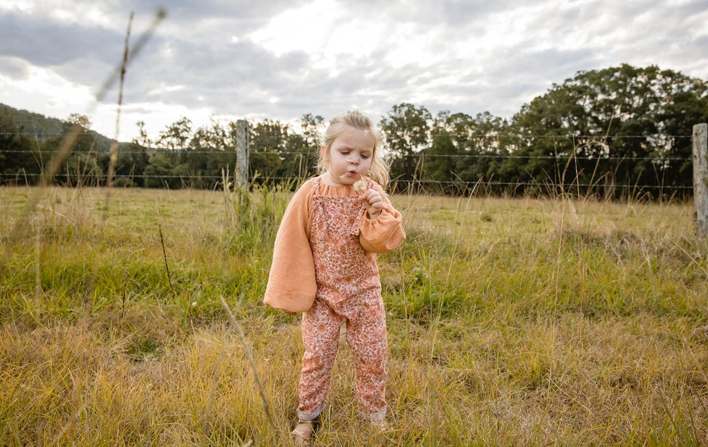 Our handmade smock tops are made with a soft muted papaya orange cotton muslin that will just get better with wear age. With a handkerchief hem and elastic cuff bell sleeves, it’s perfect layered under our overalls or paired with our harems, bloomers, frill shorts.