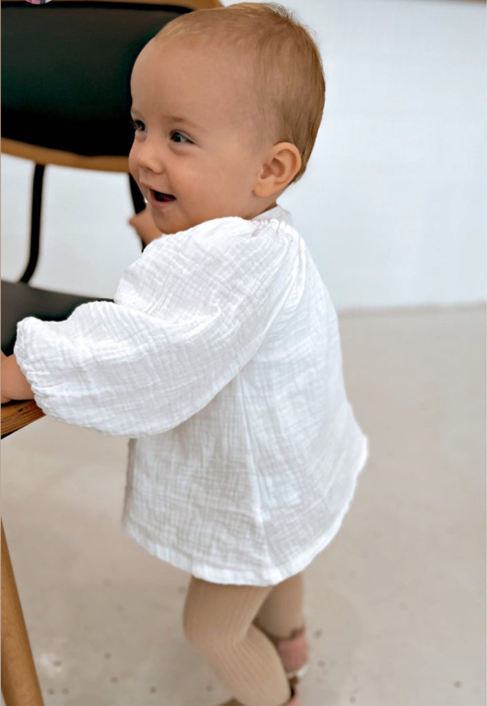 Our handmade smock tops are made with a soft white cotton muslin that will just get better with wear age. With a handkerchief hem and elastic cuff bell sleeves, it’s perfect layered under our overalls or paired with our harems, bloomers, frill shorts.