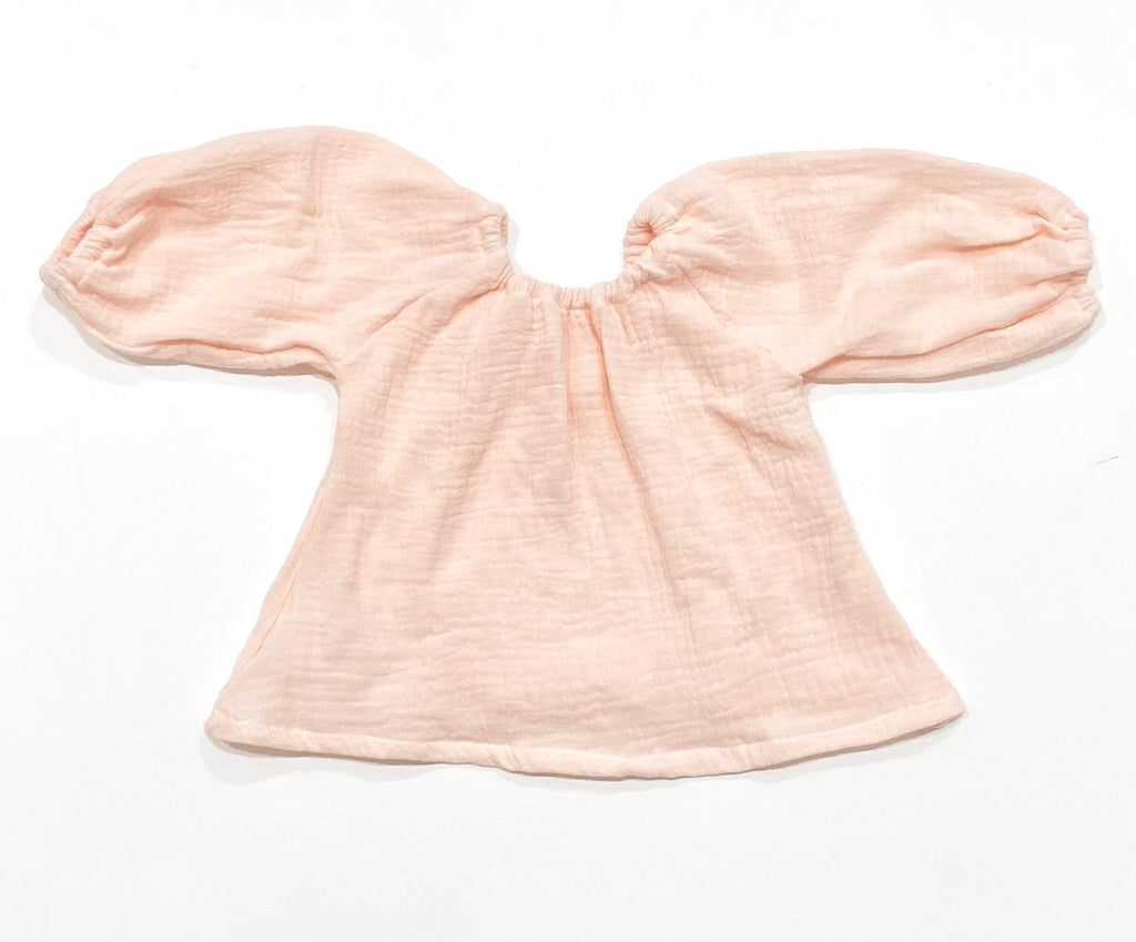 Our handmade smock tops are made with a soft gelato peach cotton muslin that will just get better with wear age. With a handkerchief hem and elastic cuff bell sleeves, it’s perfect layered under our overalls or paired with our harems, bloomers, frill shorts.