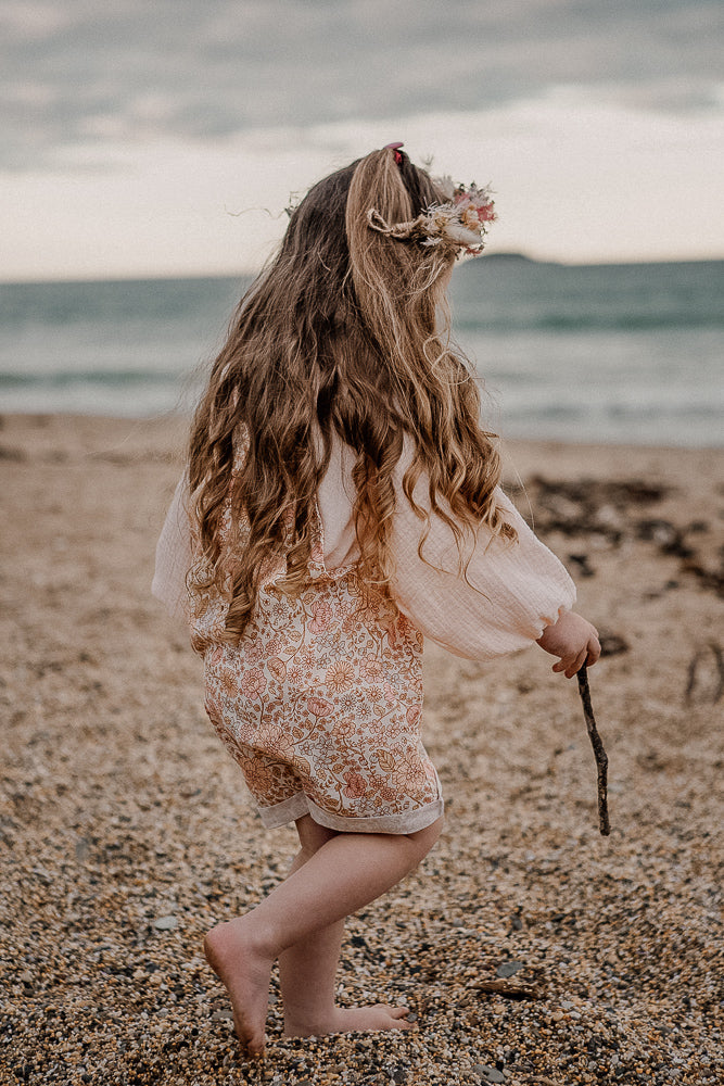 Our handmade smock tops are made with a soft gelato peach cotton muslin that will just get better with wear age. With a handkerchief hem and elastic cuff bell sleeves, it’s perfect layered under our overalls or paired with our harems, bloomers, frill shorts.